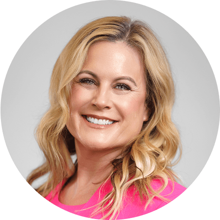 a woman in a pink shirt smiles for the camera