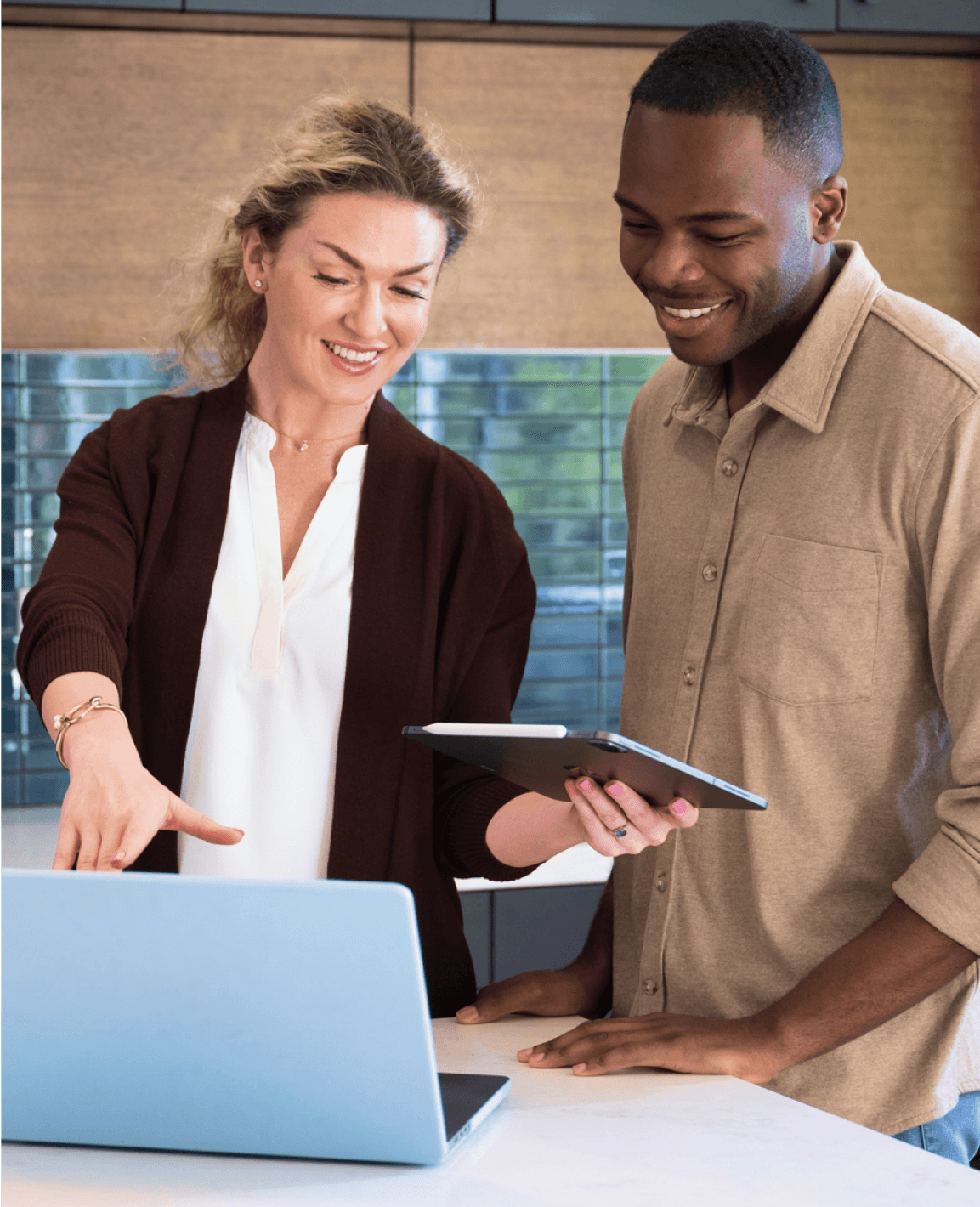 A man and a woman are looking at a laptop.