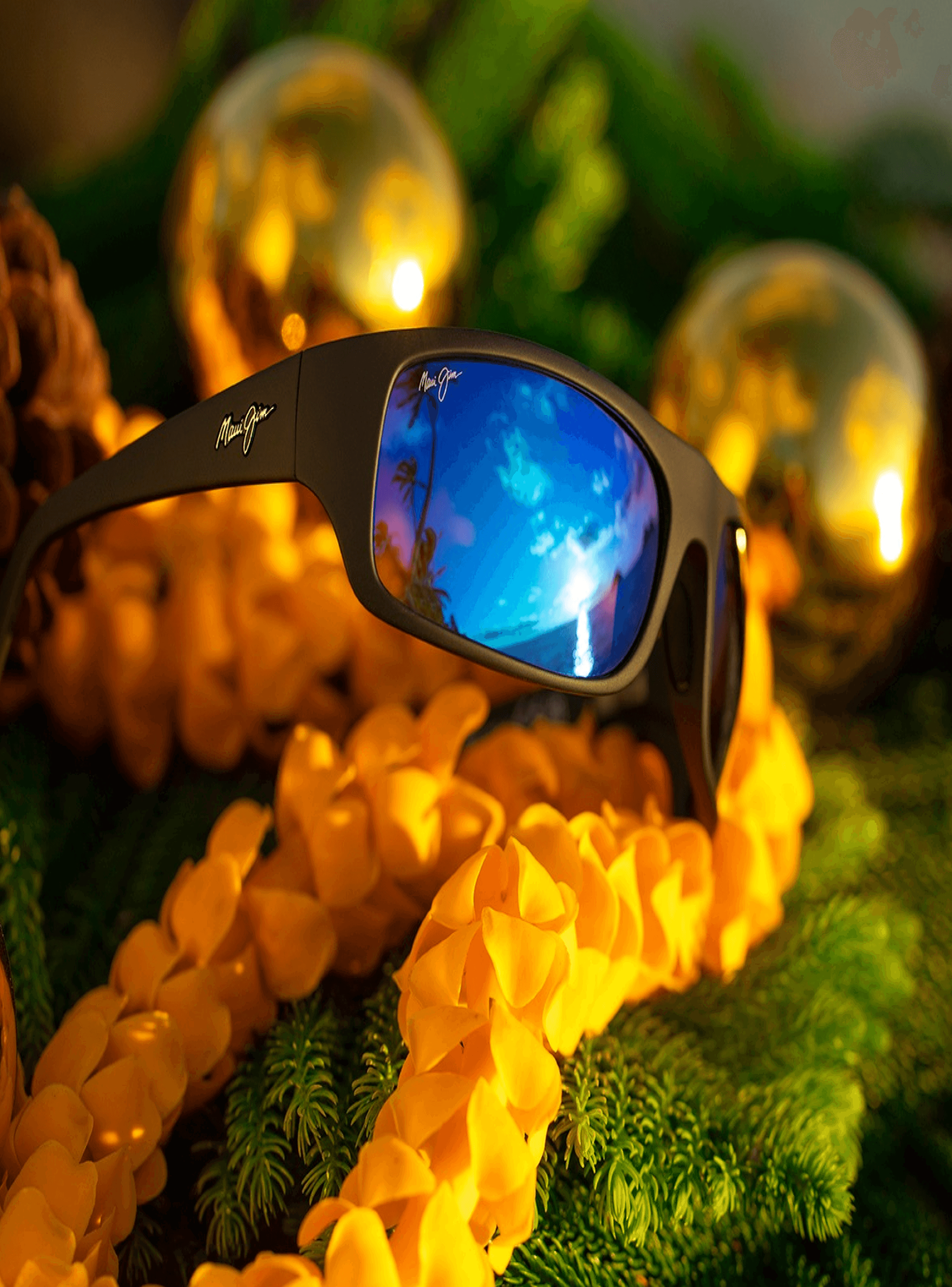 A pair of maui jim sunglasses sitting on top of a lei.
