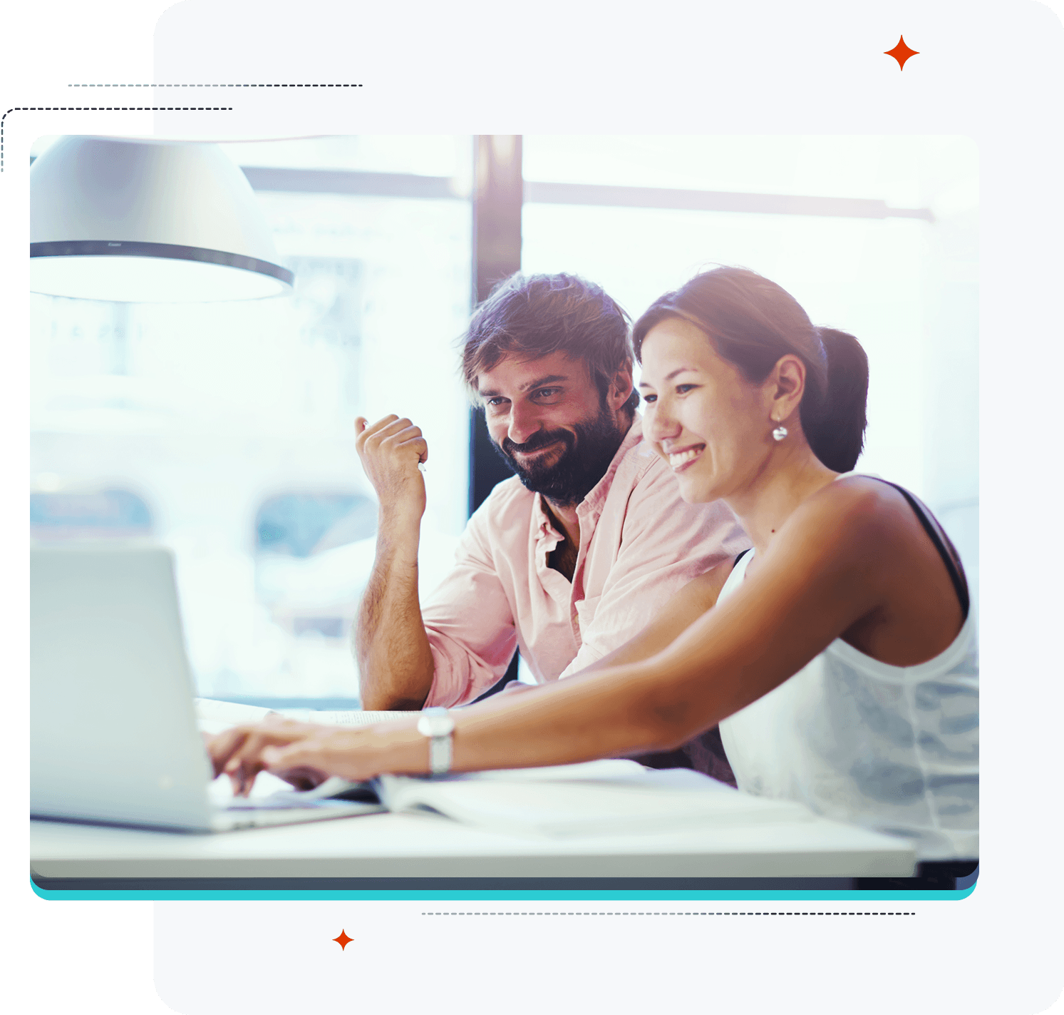 Smiling man and woman collaborating on a laptop.