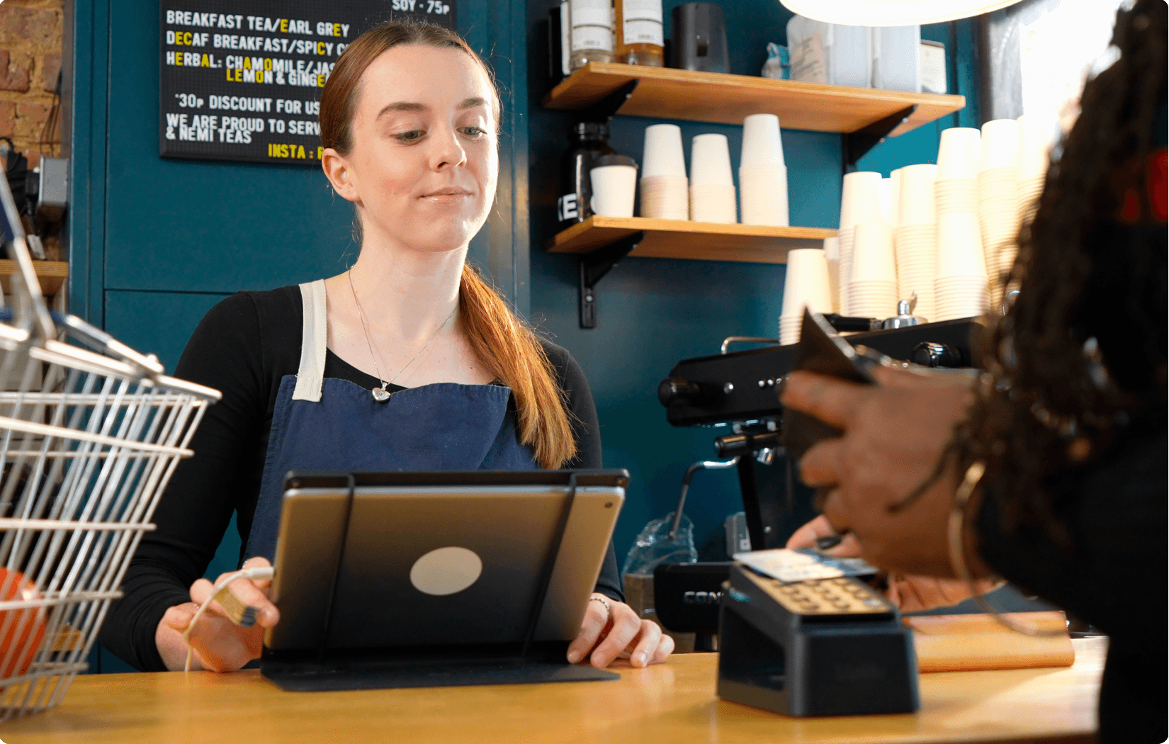 Barista looking at a mobile device.