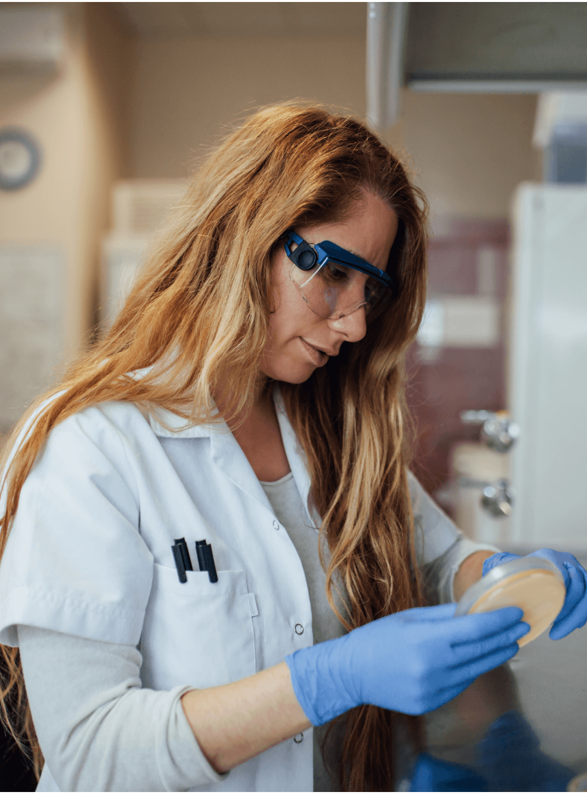 Women holding a sample tray in a lab.