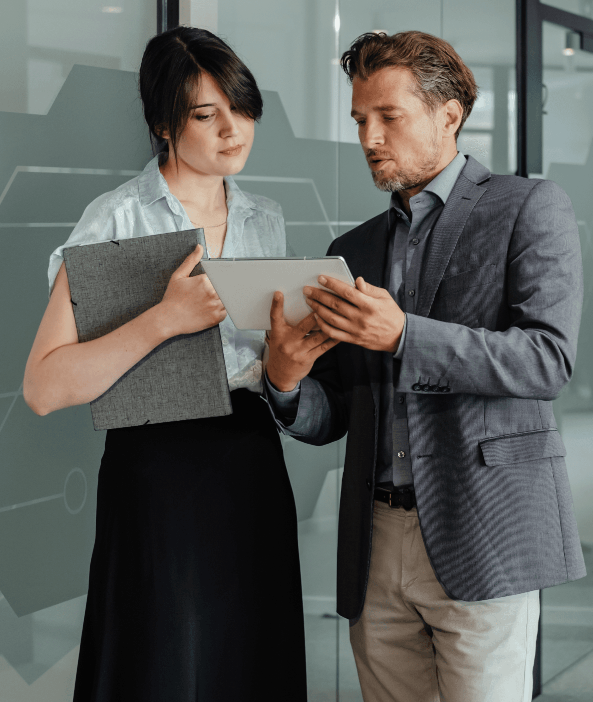 A man and a woman are looking at a tablet together.