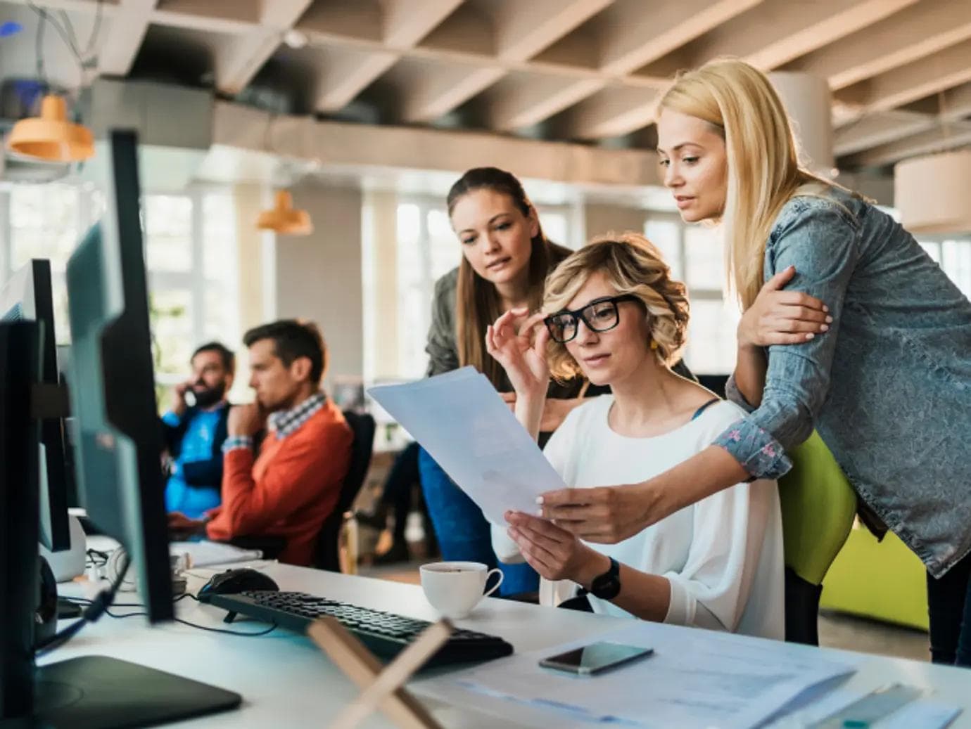 People working at a desk in an office.