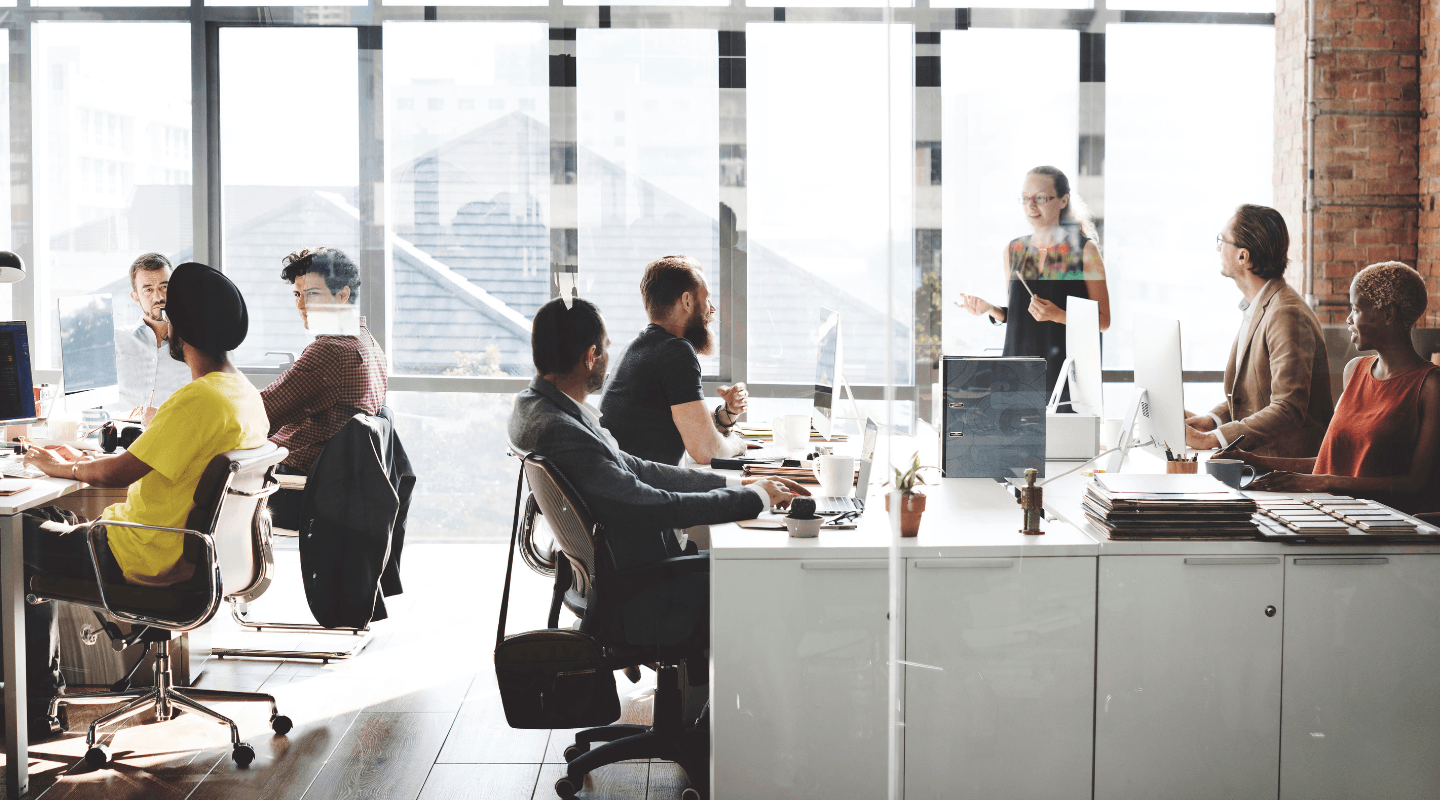 People working and collaborating in a bright, open-plan office.